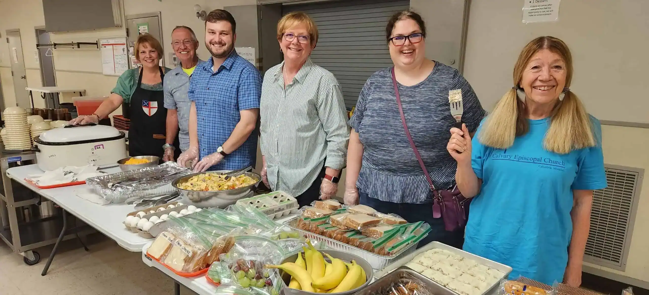 Group of people serving food at Calvary Episcopal Church event.