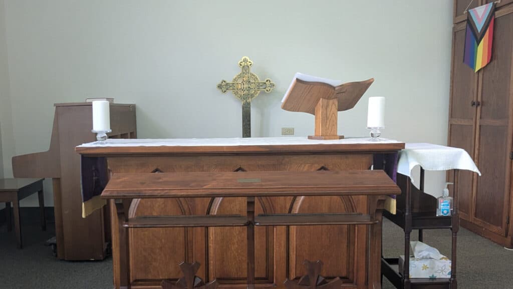 Elegant church altar with wooden cross, open Bible, and candles at Calvary Episcopal Church.