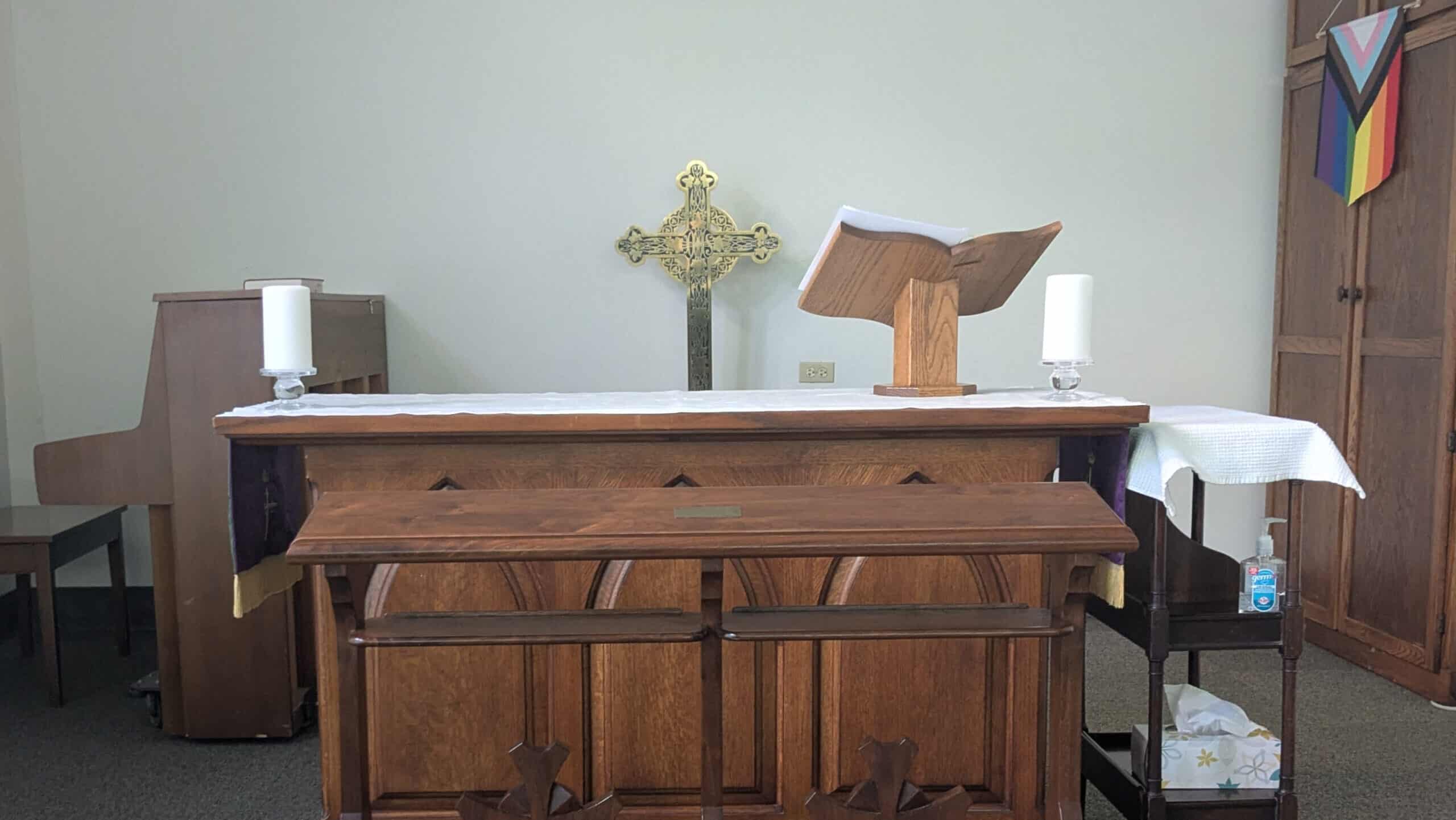 Elegant church altar with wooden cross, open Bible, and candles at Calvary Episcopal Church.