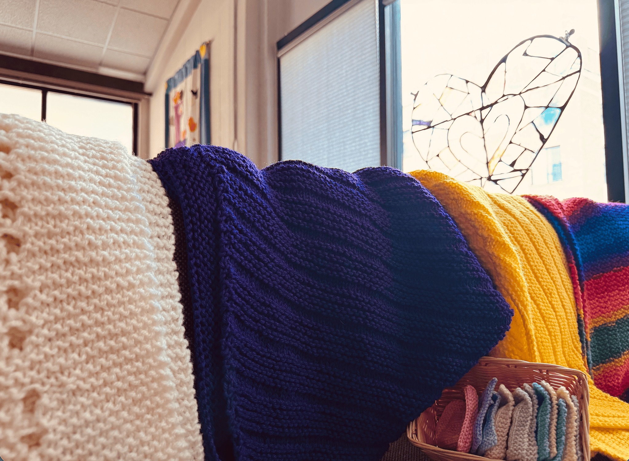 Warm knitted blankets and colorful pillows on a cozy couch at Calvary Episcopal Church.