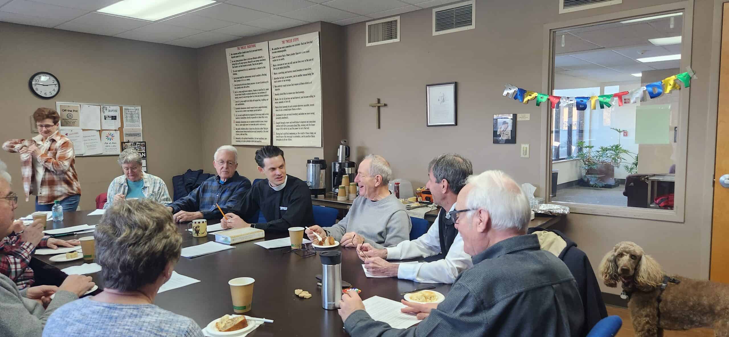 Community gathering at Calvary Episcopal Church meeting room with diverse attendees enjoying a meal.